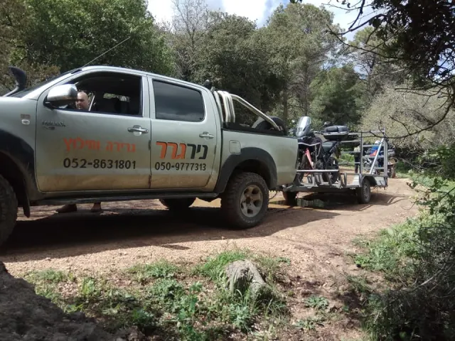 טנדר ניר גרר גורר עגלה עם אופנוע בדרך עפר
